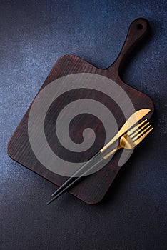 Empty rectangular wooden cutting board on dark concrete background