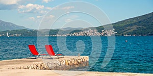 Empty red beach chairs on the pier