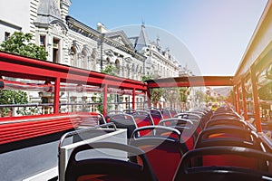 Empty red bus seats with open roof