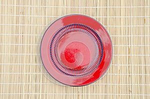 Empty red ceramic plate on table