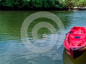 Empty red kayak floating on the water