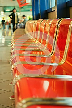 Empty red metal seats at airport hall