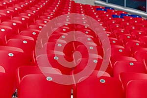 Empty red plastic chairs in a row at the football stadium