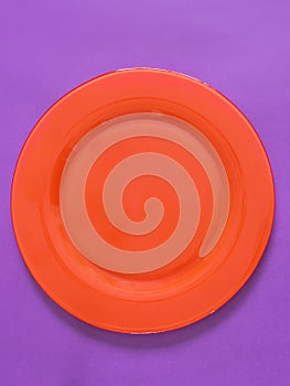 Empty red plate on purple