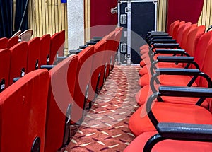 Empty red seats in a theater with patterned carpet