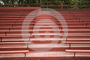 EMPTY RED WOODEN BLEACHERS