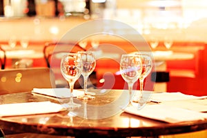 Empty restaurant background with wineglasses and napkins in front of abstract blurred restaurant lights, Paris, France