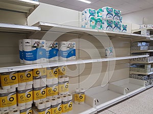 Empty retail shop shelves in supermarket.  Low supplies due to stockpiling by customers consumers due to covid 19 coronavirus