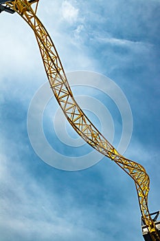 Empty ride roller coaster in amusement park on blue sky background