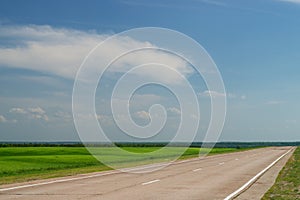 Empty road going through fields