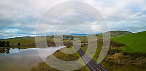 Empty road by green hills and reservoir in beautiful California at dawn photo