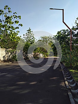 Empty road with green scenery and blue sky