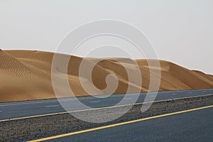 An empty road next to a desert in Dubai, UAE