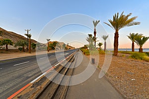 Road on the outskirts of Eilat by the coastline of the Red sea coral reef at sunset, Israel