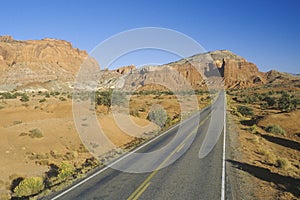 An empty road runs through red rock in the desert southwest USA