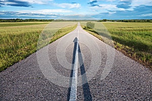 Empty road with a shadow in the shape of arrow