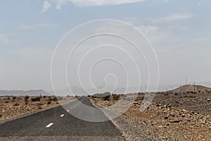 Empty road in southern Morocco with mountains in the background