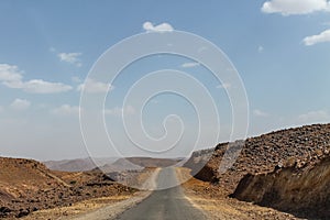 Empty road in southern Morocco with mountains in the background