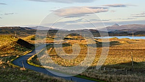 Empty road to Rannoch Moor train station in Scotland during sunset