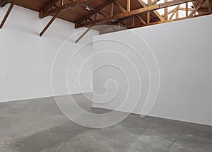 An empty room art gallery with wood ceiling and concrete flooring