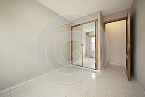 Empty room with brown and gray walls and white porcelain floors