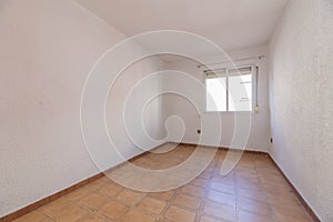 Empty room with brown stoneware floors with matching baseboards