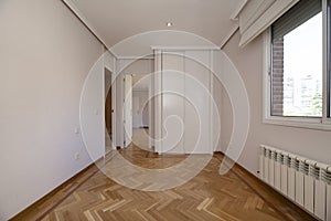 Empty room with a built-in wardrobe with white sliding doors