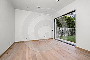 empty room with hard wood floors and sliding glass doors open