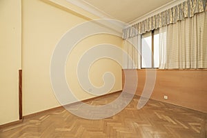 Empty room with herringbone oak flooring, cream painted walls