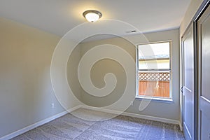 Empty room interior with beige walls and wall to wall carpet.