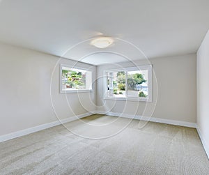 Empty room interior in light tones with carpet floor.