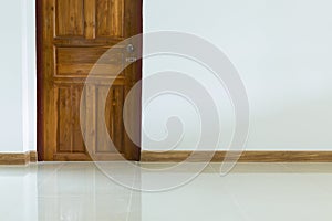 Empty room interior with wooden door and white wall