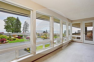 Empty room with large windows and carpet floor.