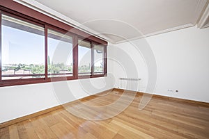 Empty room with large windows overlooking urbanization