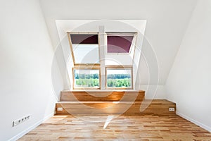 Empty Room of New Home with Wood Floors, White Walls and Bright Skylights.