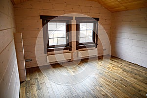 Empty room in a new wooden house, walls colored with natural paint .