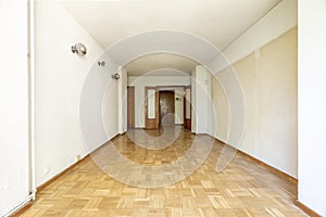 Empty room with oak parquet flooring, white painted walls