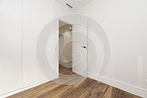 Empty room with open white wooden door, ducted air conditione photo