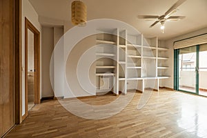 empty room with plaster shelf with glass shelves, aluminum radiators,