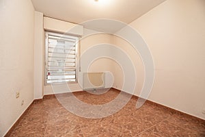 Empty room with reddish stoneware floor, aluminum window