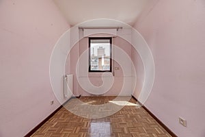 An empty room with a small red anodized aluminum window