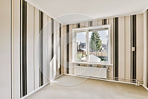 a living room with striped walls and a window