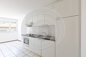 Empty room with vintage kitchen, white tiles and walls