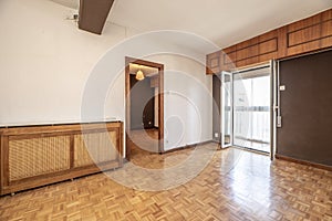 Empty room with white and dark brown painted walls, oak parquet