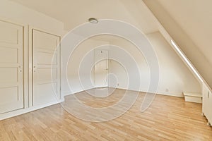 an empty room with white doors and a wooden floor