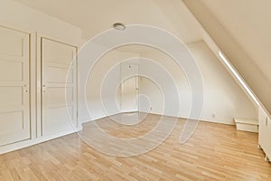 an empty room with white doors and a wooden floor photo