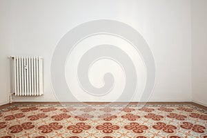 Empty room with white wall and tiled floor with floral decoration