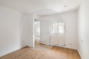 Empty room with window and hardwood floor after renovation. New apartment for rent or sale.