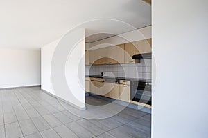 Empty room with windows and wooden kitchen