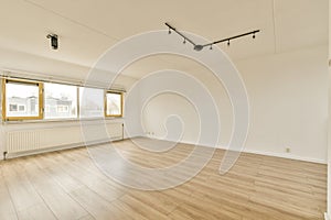 an empty living room with wood floors and a window